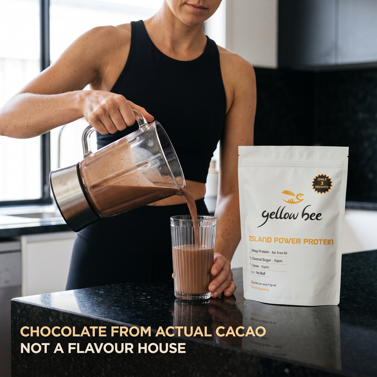 Chocolate protein shake poured from a blender into a glass beside the Island Power Protein bag on a granite benchtop